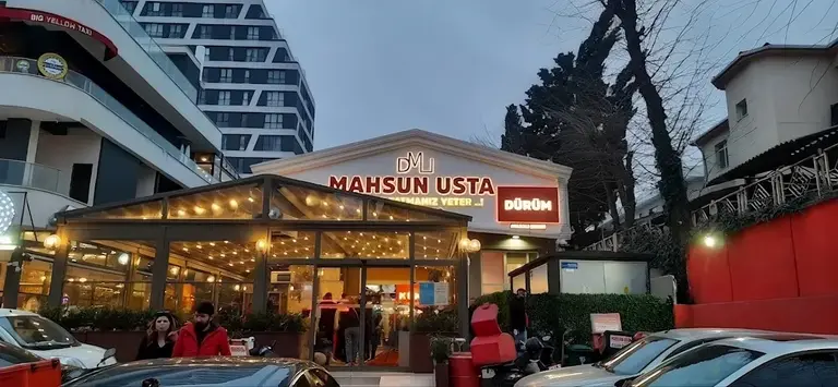 Dürümcü Mahsun Usta Halkalı şubesinin cam cepheli girişi ve tabelası, akşam