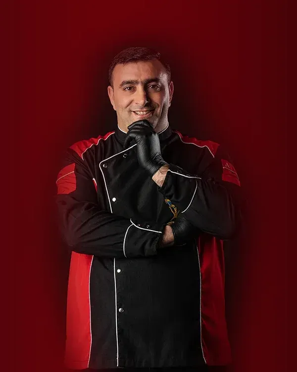 Siyah-kırmızı aşçı ceketiyle gülümseyen Mahsun Gökçur